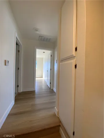 a view of a hallway with wooden floor