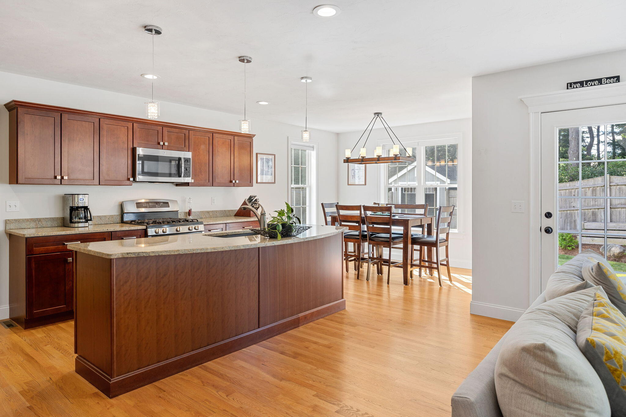 48 Meadowbrook Road Mashpee, MA 02649 - Photo 17 of 52 a kitchen with stainless steel appliances granite countertop a stove top oven a sink a dining table and chairs with wooden floor