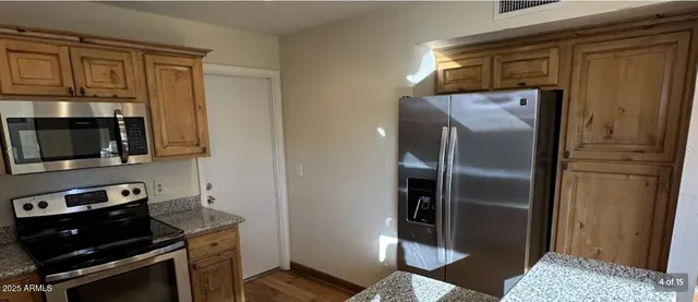 a metallic refrigerator freezer sitting in a kitchen