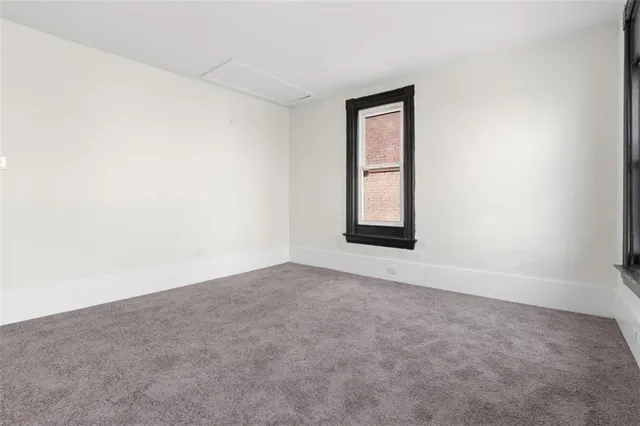 an empty room with windows and closet