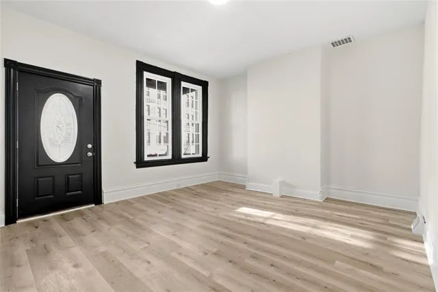 a view of a room with wooden floor and mirror