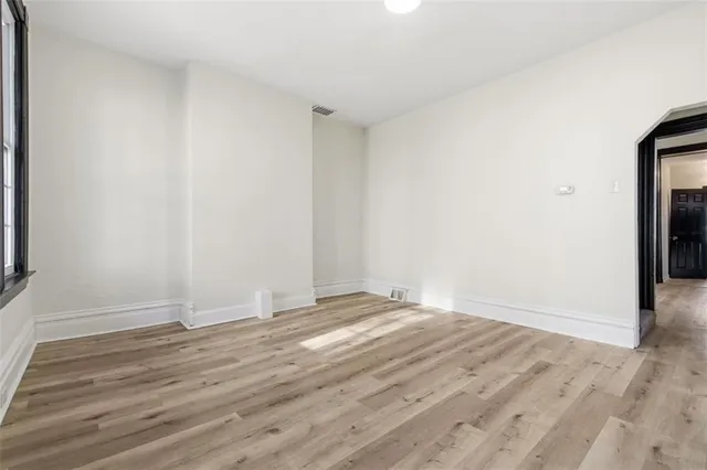 a view of an empty room with wooden floor
