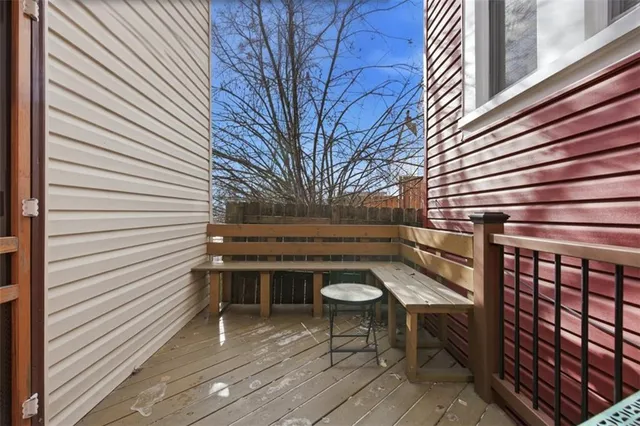 a view of a patio with table and chairs with wooden floor and fence