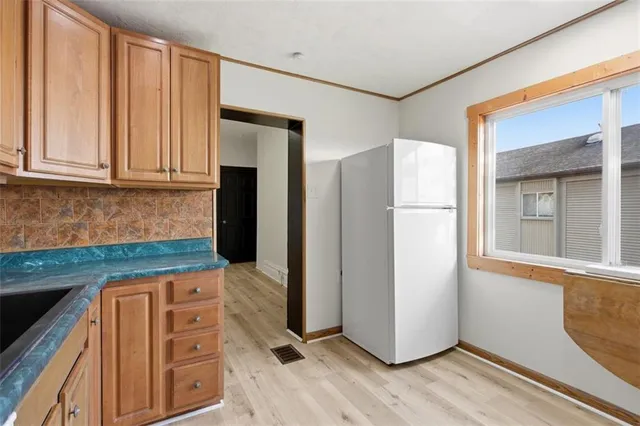 a kitchen with granite countertop a refrigerator and a stove top oven