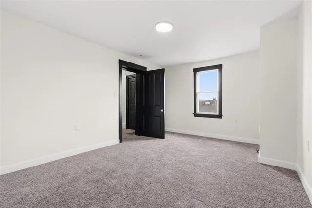 an empty room with closet and a window
