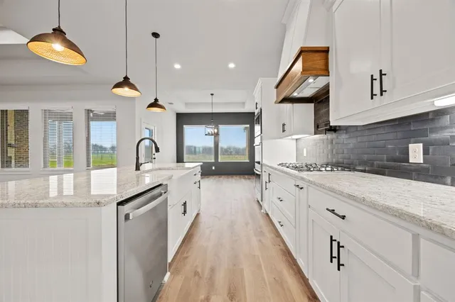 a kitchen with kitchen island white cabinets and sink