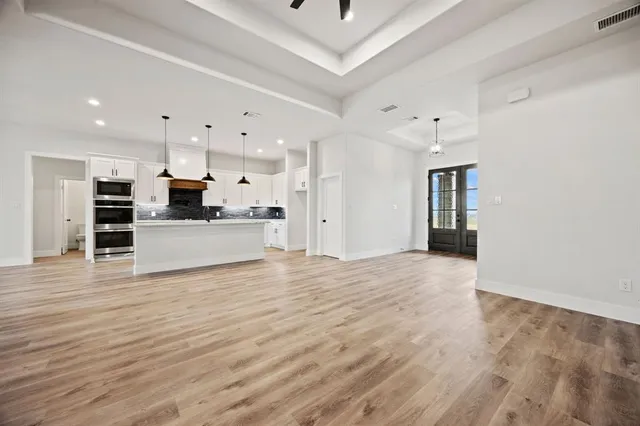 a view of a kitchen with white cabinets and stainless steel appliances