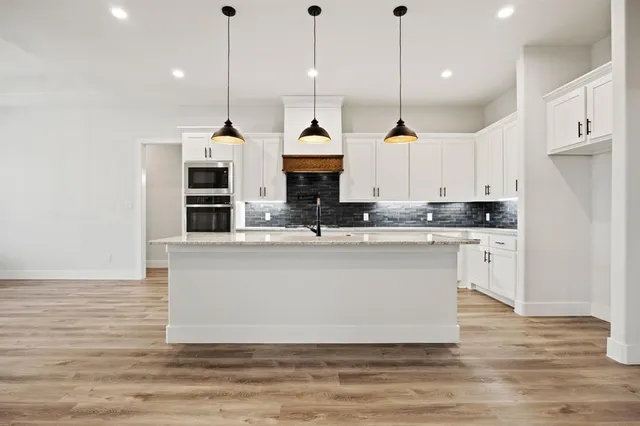 a view of kitchen with stainless steel appliances granite countertop sink