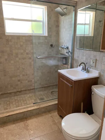 a bathroom with a sink a toilet and shower