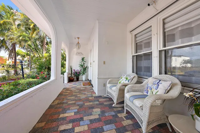 a living room with patio furniture and a floor to ceiling window