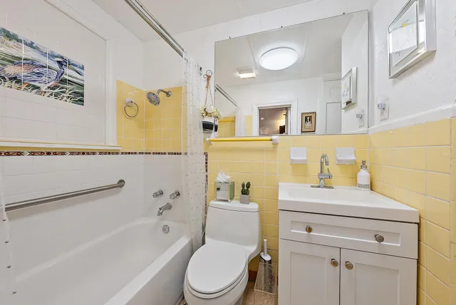 a bathroom with a sink toilet vanity and bathtub