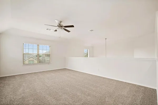 an empty room with fan and windows