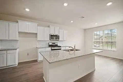 a kitchen with sink refrigerator and microwave