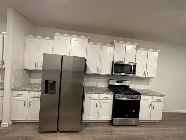 a kitchen with stainless steel appliances a refrigerator stove and microwave