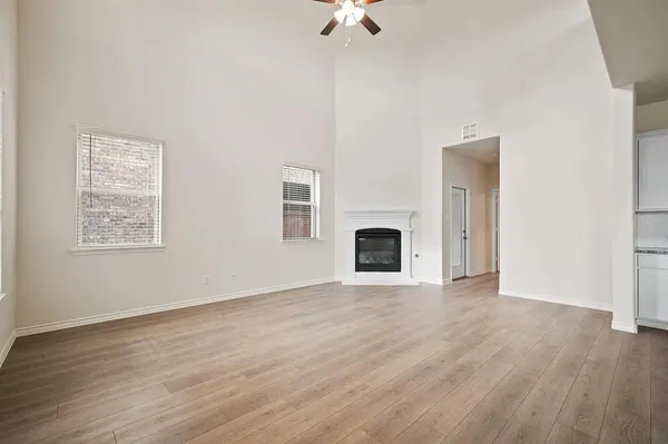a view of empty room with wooden floor and fireplace