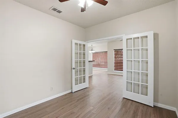 an empty room with wooden floor and windows