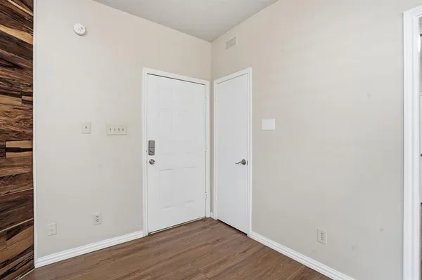 a view of an empty room with wooden floor