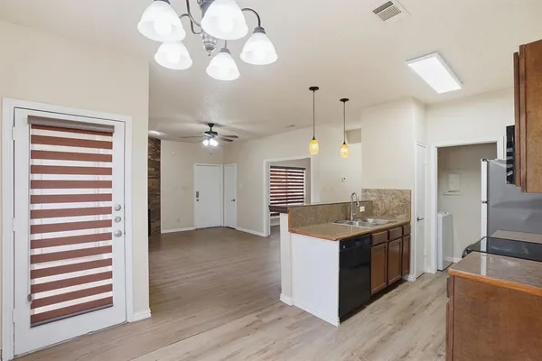 a kitchen with a stove chandelier and wooden floor