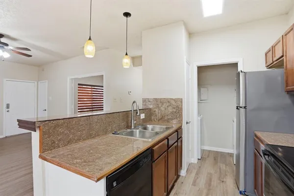 a kitchen with stainless steel appliances granite countertop a sink and a refrigerator