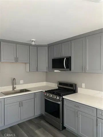 a kitchen with sink a microwave and cabinets