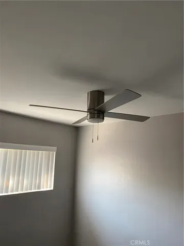 a view of a room with window and a ceiling fan