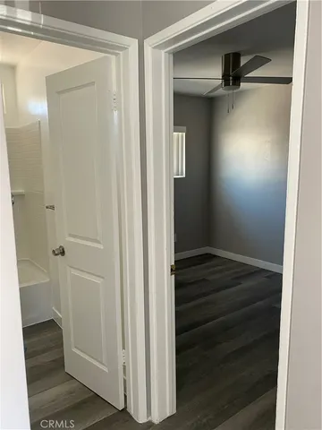 a view of a hallway with closet and wooden floor