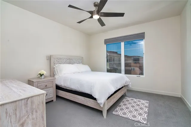 a bed sitting in a spacious bedroom next to a window