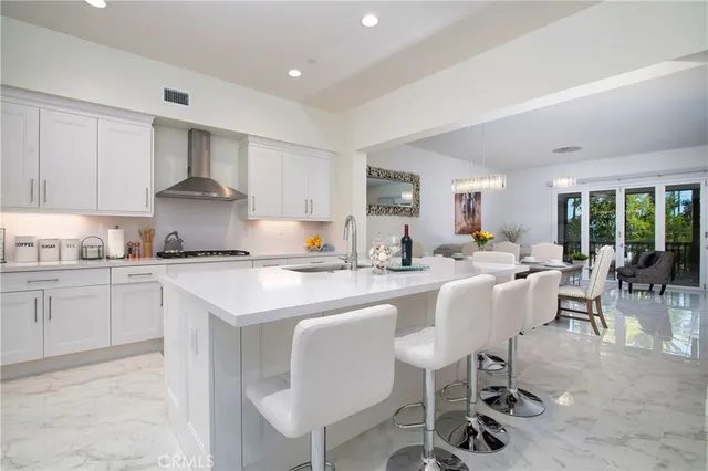 a kitchen with a dining table chairs and white cabinets