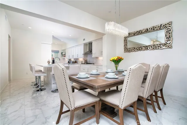 a kitchen with a dining table chairs and white cabinets