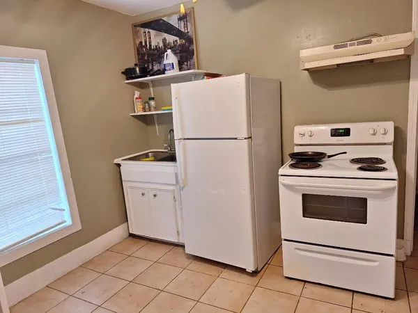 a white refrigerator freezer and a stove sitting inside of a kitchen