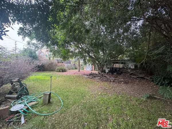 a backyard of a house with fountain table and chairs