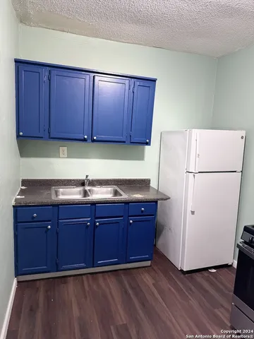 a kitchen with wooden cabinets and white appliances