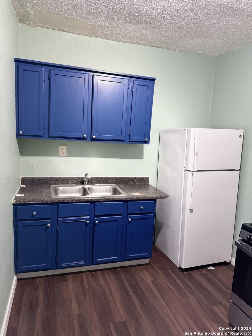 1902 Lennon Avenue, Unit 2 San Antonio, TX 78223 - Photo 6 of 16 a kitchen with wooden cabinets and white appliances