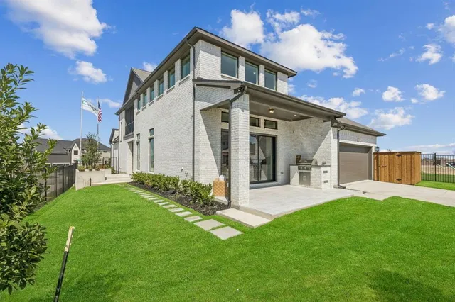 a front view of a house with a yard and trees