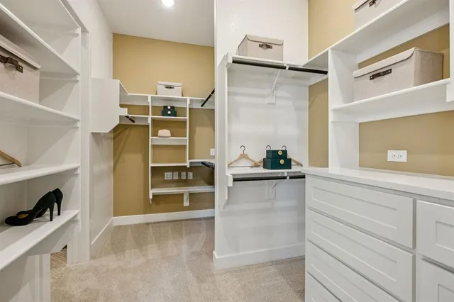a view of walk in closet with clothes and shoes