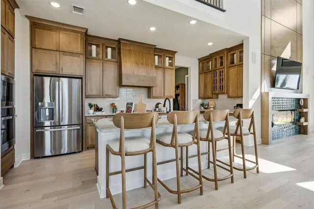 a kitchen with stainless steel appliances kitchen island granite countertop a refrigerator and microwave