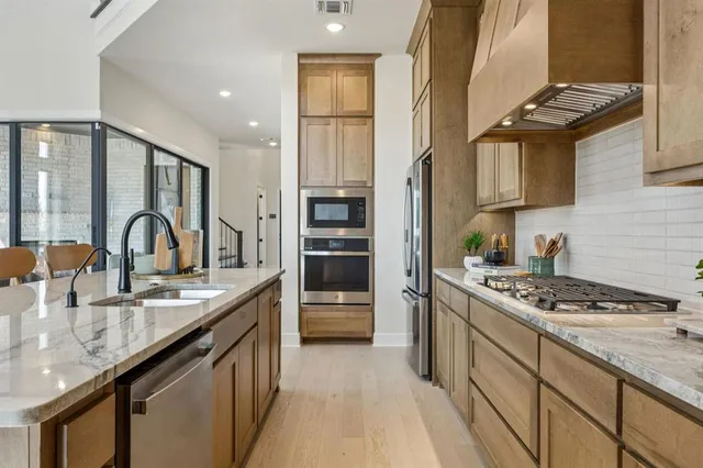 a kitchen with stainless steel appliances granite countertop a sink stove and cabinets