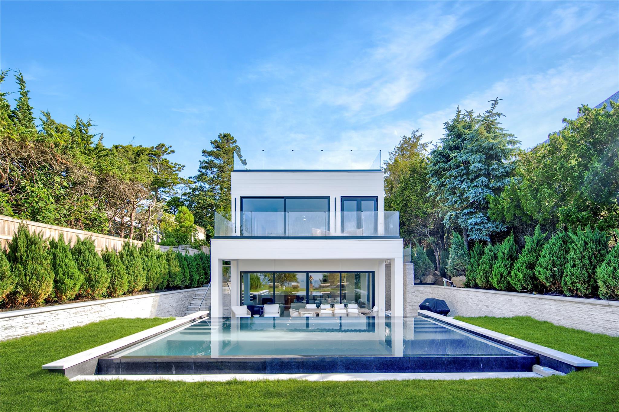 a view of pool with seating area and trees in the background