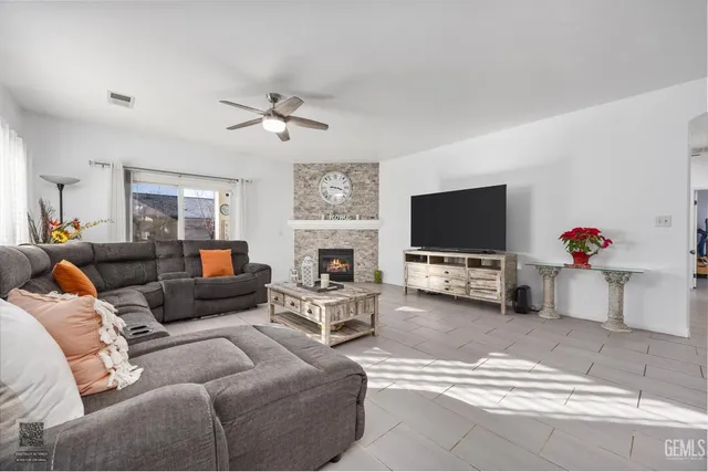 a living room with furniture a flat screen tv and a fireplace