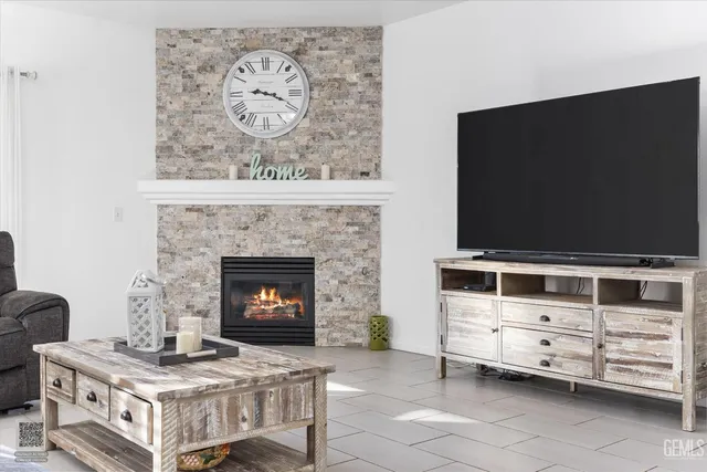 a living room with furniture a flat screen tv and a fireplace
