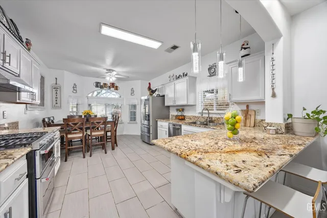 a kitchen with granite countertop sink cabinets and stainless steel appliances