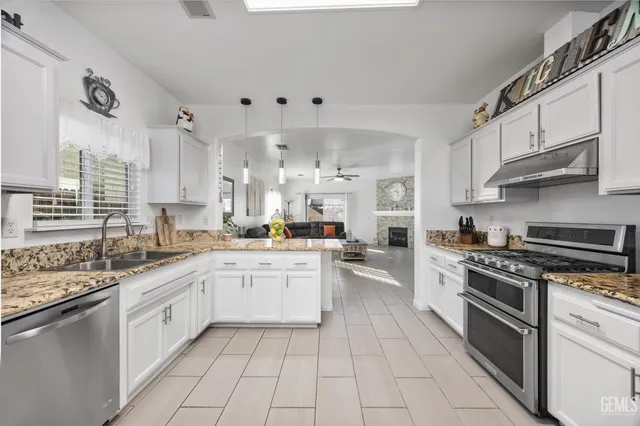 a kitchen with stainless steel appliances granite countertop a sink and cabinets