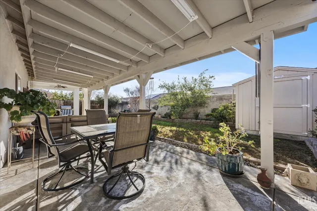 a view of a patio with table and chairs potted plants and large tree