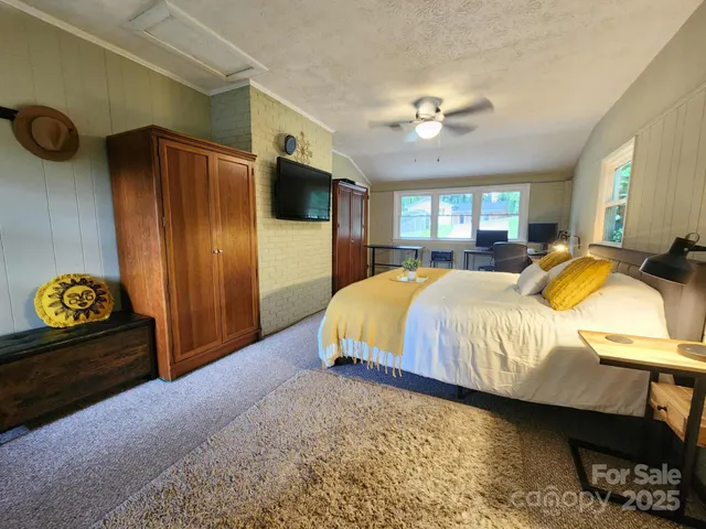 a spacious bedroom with a bed and a chandelier