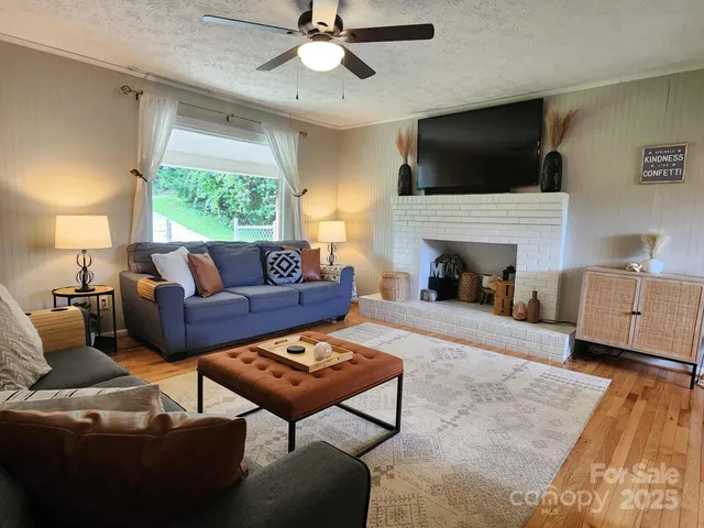 a living room with furniture a fireplace and a flat screen tv