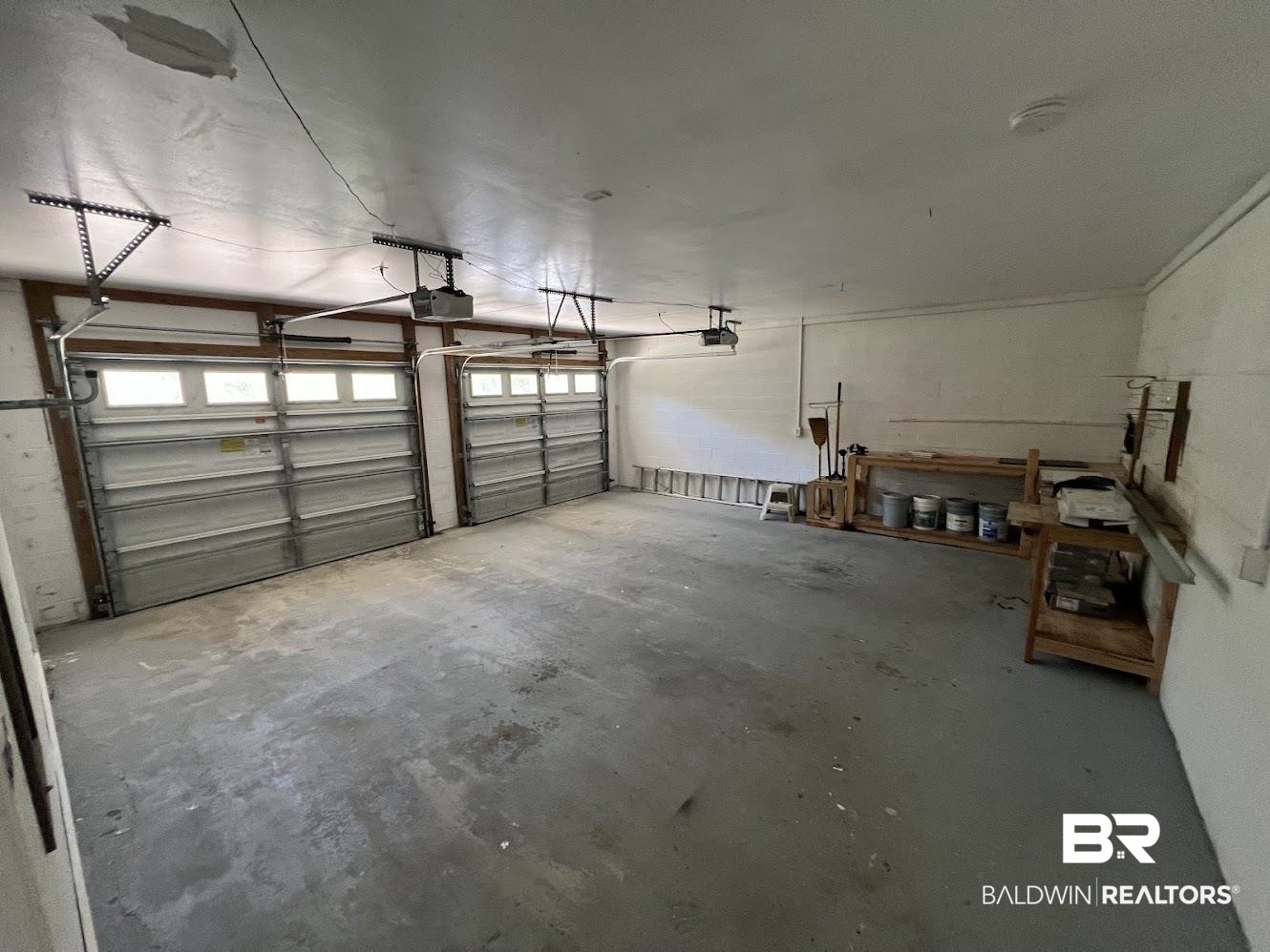 266 Ridgewood Drive Daphne, AL 36526 - Photo 26 of 34 Two-car garage featuring a concrete floor, two garage door openers, and built-in shelving