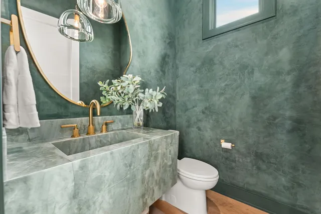 a bathroom with a granite countertop sink a toilet and a mirror