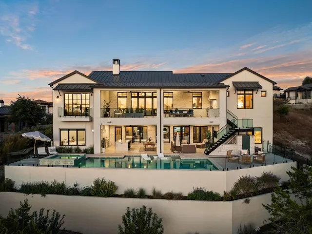 a front view of a house with a yard and lake view