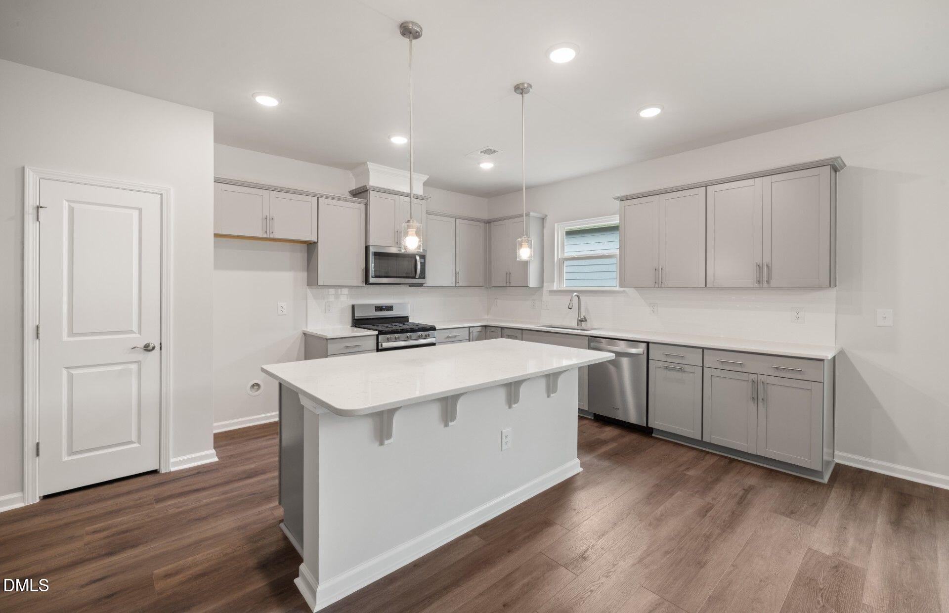 316 Broomside Avenue Raleigh, NC 27603 - Photo 3 of 31 a kitchen with a sink a stove a refrigerator and white cabinets