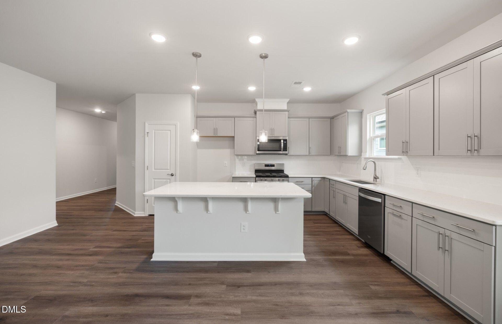 316 Broomside Avenue Raleigh, NC 27603 - Photo 6 of 31 a large kitchen with stainless steel appliances kitchen island a large counter top and wooden floors